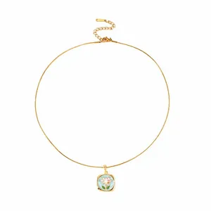 Dettaglio della collana vintage dorata con pendente quadrato in smalto blu e fiori rosa