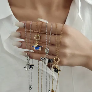 Close-up of graduation themed necklaces with heart charms and Class Of book pendants