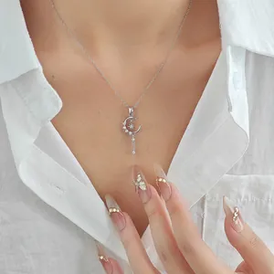 Detail view of silver moon and star tassel necklace with sparkling zircon on model neck