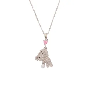 Detailed view of silver bear necklace with pink heart stone and pearl pendant decoration