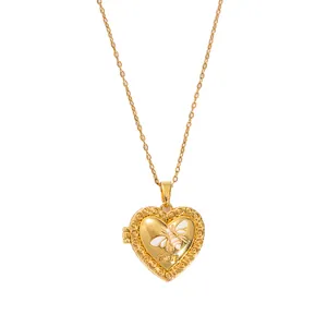Detail of a golden heart locket necklace featuring a white bee motif and LOVE engraving