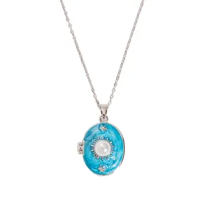 Macro shot of oval locket necklace with blue enamel and faux pearl inlay