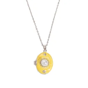 Detail of vintage oval yellow enamel locket necklace with star and pearl inlay