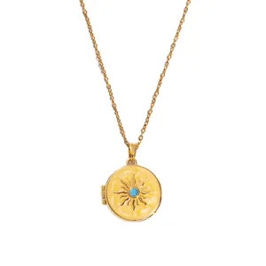 Detailed close-up of a vintage gold locket necklace with sunburst pattern and turquoise stone