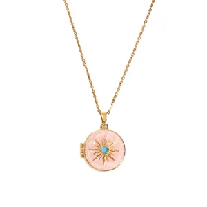 Macro shot of gold vintage locket with pink enamel sunburst and turquoise center