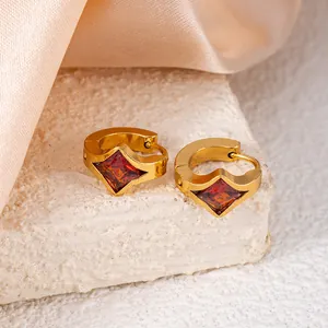Golden titanium steel hoop earrings featuring square red cubic zirconia stones