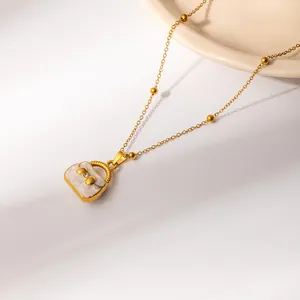 Gold stainless steel necklace with cream handbag pendant and bowknot detail