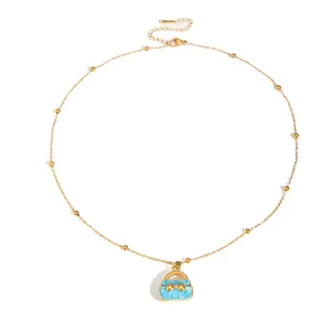 Golden beaded necklace with blue enamel handbag pendant and small bow with zircon