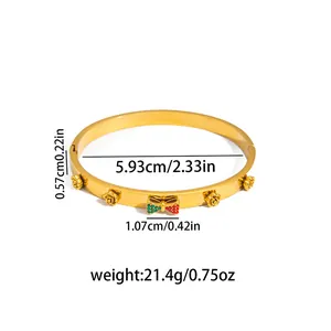 Elegant gold titanium bracelet featuring 3D roses and a red-green rhinestone bow charm