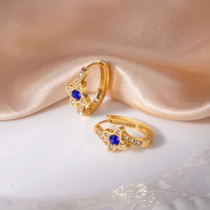 Orecchini a cerchio dorati con motivo a stella, zircone blu e piccoli cristalli