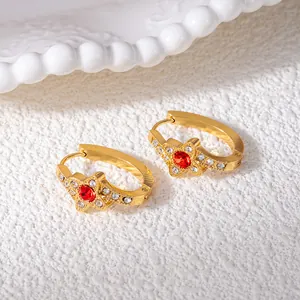 Eleganti orecchini a stella dorati con zircone rosso e pietre bianche lucenti