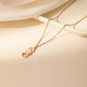 Modieuze gouden zeepaardje ketting met roze emaille hanger aan een fijne schakel