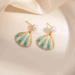 Elegant gold shell drop earrings with white pearls and green enamel wave patterns