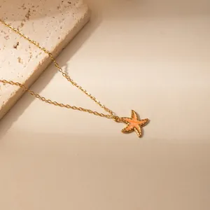 Gouden ketting met een levendige oranje zeester hanger aan een fijne delicate schakel
