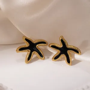 Boucles d'oreilles étoile de mer dorées avec émail noir et bords perlés ciselés