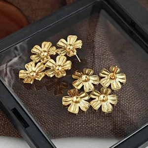 Dreilagige goldene Blumenstecker mit gebürsteter Metallstruktur in einer Premium-Displaybox