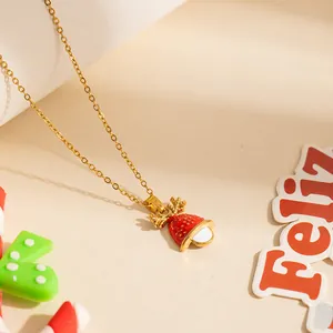 Collana natalizia con renna dorata e ciondolo a campana smaltato rosso su fondo beige