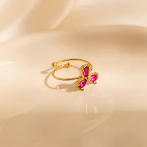 Adjustable gold ring featuring three magenta teardrop zircons in a clover shape