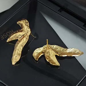 Elegante goldene unregelmäßige Blatt-Ohrringe mit gebürsteter Textur auf schwarzer Box