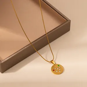 Golden zodiac pendant necklace with red and green stars and sparkling crystals