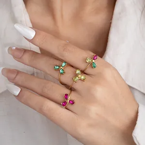 Close-up of four gold rings with butterfly zircon stones worn on model hand