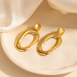 Boucles d'oreilles minimalistes dorées avec nœud et cœur sur de la soie blanche pure