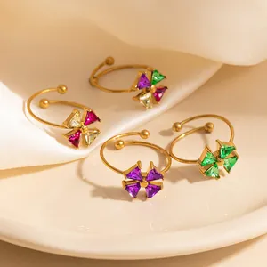 Detail of four floral open rings in gold finish with colorful zircon stone petals