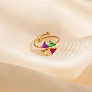 Macro shot of an adjustable gold ring with four multi-color triangle gemstones on silk