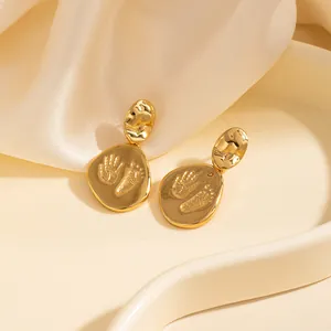 Boucles d'oreilles minimalistes dorées avec gravures de mains et pieds de bébé