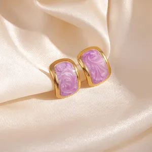 Boucles d'oreilles dorées avec émail lavande sur fond de soie champagne élégant et chic