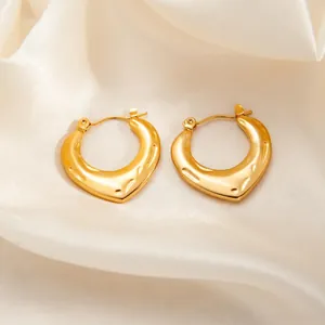 Luxe chunky gold twisted hoop earrings with irregular texture on satin background