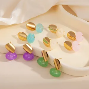 Boucles d'oreilles ovales dorées avec pendentifs en résine colorée sur soie blanche