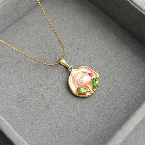 Golden rose pendant necklace with pink enamel and pearl on velvet jewelry box