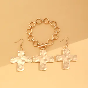 Detailansicht des goldenen Kreuz-Schmucksets mit klobigem Armband und Ohrringen