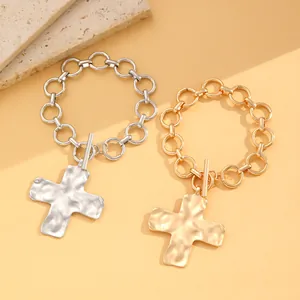Detailaufnahme grober Metallketten-Armbänder mit Hammerschlag-Kreuzanhänger und OT-Verschluss