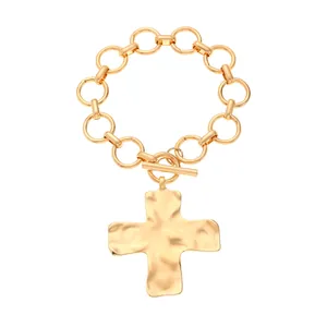 Detailansicht eines goldenen Gliederketten-Armbands mit Kreuzanhänger und T-Verschluss