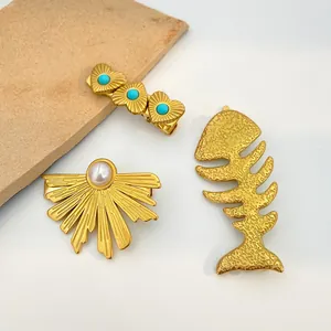 Detail of vintage gold hairpins with turquoise hearts, pearl fans, and fishbone texture