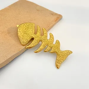 Golden fishbone metal hair clip with hammered texture and minimalist spring design