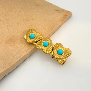 Golden heart hair clip with turquoise beads and sunburst relief on minimalist stone base