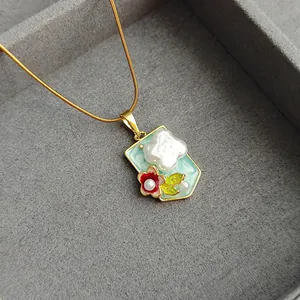 Gold snake chain necklace with light blue floral pendant and baroque pearl cloud details