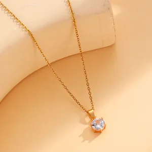 Détail macro d'un pendentif en zircon rond brillant sur une fine chaîne dorée