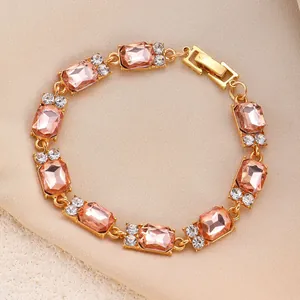 Elegante bracciale dorato con cristalli rosa rettangolari e accenti bianchi scintillanti