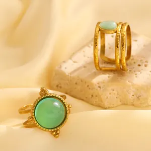 Detail von Vintage vergoldeten Ringen mit grünem Stein auf strukturiertem Steinuntergrund