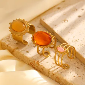Dreiteiliges Retro-Goldring-Set mit bunten ovalen Steinen auf Steinhintergrund