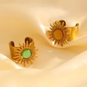 Nahaufnahme vintage goldener offener Ringe mit grünen und bernsteinfarbenen Steinen