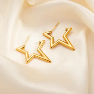 Elegant gold star-shaped hollow stud earrings on soft silk fabric with a polished finish