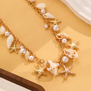 Dettaglio ravvicinato di ciondoli a forma di stella marina e perle su collana dorata
