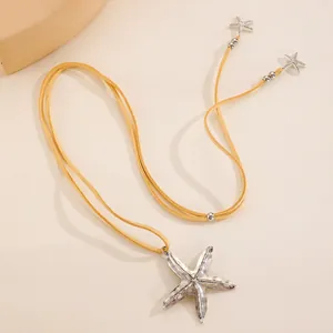 Détail du pendentif étoile de mer vintage avec cordon en daim gingembre et perles en métal