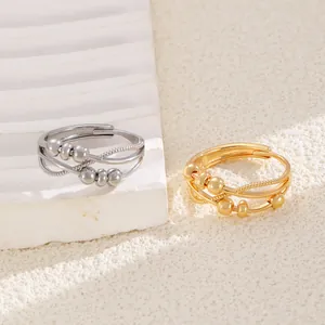 Detailed view of layered fidget rings with movable beads in gold and silver finishes