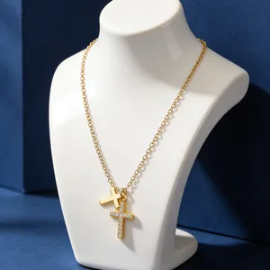 Detail of double cross pendant necklace with zircon pavé and polished gold finish